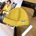 Detail shot of bright yellow knitted kids beanie with PPSW label and ribbed texture - 3 Years+ to Adult / Yellow