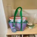 Large capacity purple and green mesh tote bag with matching round coin purse on a shelf - Purple