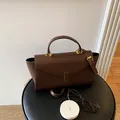 Sophisticated brown textured leather crossbody handbag featuring a chic top handle design - Brown