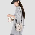 Détail d'un mini sac à bandoulière beige pour femme porté par un mannequin en style décontracté - Khaki