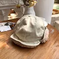 Detail view of a beige winter trapper hat featuring soft pink plush fleece earflaps - 55-58cm / Beige