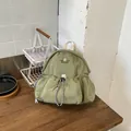 Vista lifestyle de una mochila de pana verde con práctico bolsillo de cordón frontal - Verde