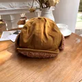 Ginger trapper hat with soft sherpa ear flaps placed on a rustic wooden table scene - 55-58cm / Camel