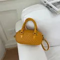 Vista detallada de bolso amarillo de textura tejida con hebillas y asas superiores de plata - Amarillo