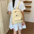 Detailed back view of a stylish vintage yellow backpack ideal for school or daily commuting. - Creamy Yellow (With Charm)