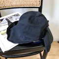 Detalle de un sombrero de sol negro de ala ancha con un elegante lazo en la parte posterior. - 56-58cm Ajustable / Negro