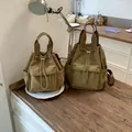 Par de mochilas caqui con cordón en dos tamaños sobre mesa de madera. - L / Caqui