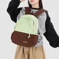 Detailed macro view of a green and brown patchwork school backpack with a plush charm - With Charm / Coffee Green