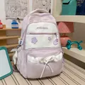 Detailed view of a purple school backpack with star embroidery and a white ribbon bow. - With Charm / Purple