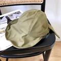 Vista detallada de un sombrero de sol para mujer verde oliva con lazo en una silla - 56-58cm Ajustable / Verde Militar