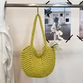 Detailed view of a hand-woven lime green crochet shoulder bag with floral props - Bean Green