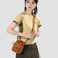 Mannequin portant un mini sac bandoulière léger beige pour femme style décontracté chic - Marron