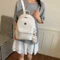 Stylish white woven college backpack for students shown in a casual lifestyle setting. - White (with Pendant)