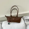 Gros plan d'un sac sous les aisselles marron avec des breloques en pierre colorées - Avec Pendentif / Marron