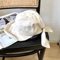 Vista detallada de un elegante sombrero de pescador de algodón blanco con un gran lazo. - 56-58cm Ajustable / Beige