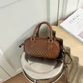 Detailed close-up of a brown woven texture pill handbag with premium silver hardware - Brown