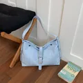 Close-up detail of light blue fashion casual women's shoulder tote bag in home setting - Blue