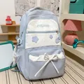 Close-up of light blue polka dot backpack with bow and star details on a student desk - With Charm / Blue