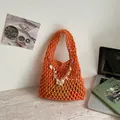 Κομψή πορτοκαλί πλεκτή τσάντα με κοχύλι σε μοντέρνο σκηνικό γραφείου σπιτιού - Πορτοκαλί