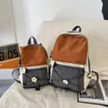 Detail view of large and small color-block hiking backpacks in cream, orange and grey - L / Orange