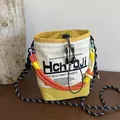 Lässige Beuteltasche mit Nischendesign, bunten Flechtseilriemen und Umhängefunktion - Gelb