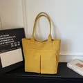 Vista frontale della borsa tote in tela gialla con due tasche e cuciture bianche - Giallo