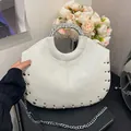 Elegant white designer handbag with silver rivets and a metallic circular handle - White