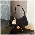 Elegante borsa sottobraccio in jacquard nero con ciondolo rosa portafortuna in mano. - con portachiavi / Nero