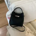 Detailansicht der schwarzen Leder-Beuteltasche mit Silberverschluss und Teddy-Anhänger - Schwarz Mit Anhänger