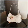 Dettaglio della borsa a spalla bianca con motivi a farfalla e ciondolo - con portachiavi / Argento