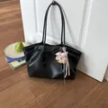 Detailed view of black faux leather tote bag with a cute poodle charm - With Charm / Black