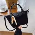 Sac à main dumpling en suédine noire avec breloque en perles et bandoulière - Noir
