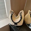 Cream woven bucket bag with black beaded handle shown in a lifestyle setting - Off White