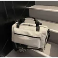 Borsone da viaggio beige capiente su scale, stile sportivo moderno per palestra. - Bianco avorio