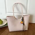 Elegant pink woven shoulder tote bag with a decorative pendant, perfect for daily use - With Pendant / Pink