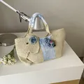 Bolso tote de paja de elefante hecho a mano en color beige con detalles de flores azules - Blanco Roto