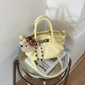 Stylish yellow mini bucket tote bag with bear charm and textured leather finish - With Pendant / Yellow