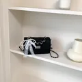 Elegant women's black quilted mini crossbody bag with a decorative pearl and lace bow - With Charm / Black