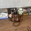 Elegante borsa a secchiello marrone lucido con ciondolo a forma di orso e tracolla donna - con portachiavi / Marrone