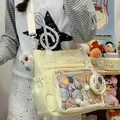 Model wearing a light yellow canvas crossbody bag with a clear window for anime pins - With Charm / Yellow
