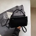 Close-up of a stylish black suede-like handbag with a handle and shoulder strap - Single Bag / Black