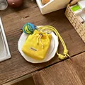 Detail view of yellow mesh drawstring bucket bag with the ChicCraze brand label - With Charm / Yellow