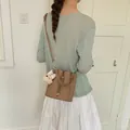 Stylish khaki brown bucket bag for women with cute plush charm and crossbody strap - With Charm / Khaki