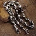 Vue macro détaillée d'un collier chaîne tête de mort hiphop vintage avec plaqué argent - Style Crâne / Argent Antique