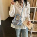Chic light blue denim cylinder handbag with cute cat print and decorative bow charm - Blue with Charm
