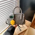 Modern gray Boston handbag with yellow pineapple charm and adjustable shoulder strap - With Charm / Gray