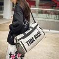 Fashionable casual white nylon duffle bag with TIDE RICE print carried by a model outdoors - With Tag / Khaki
