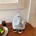 Light blue mini backpack for women featuring a large bow charm and heart pendant detail - With Charm Style / Blue with Charm