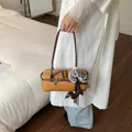 Stylish mustard yellow Boston shoulder bag featuring a cute dachshund charm and checkered ribbon - With Pendant / Yellow Brown