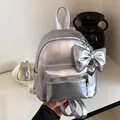 Fashionable silver metallic mini backpack for women with a cute bow charm accessory - With Charm Style / Silver (With Pendant)